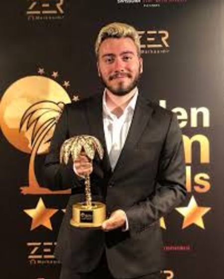 He is wearing a black coat and pants with white shirt.